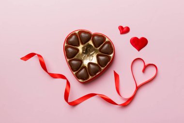 Sevgililer Günü için kırmızı kutuda lezzetli çikolatalı pralinler. Kalp şeklinde çikolata kutusu, fotokopi alanı ile üst görünüm..