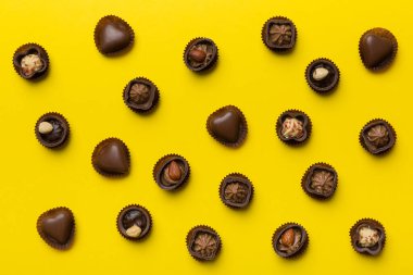 Renkli masa üzerinde farklı çikolata çeşitleri var. Üst Görünüm ve Düz Yatay.