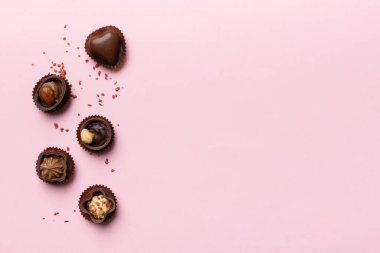 Renkli masa üzerinde farklı çikolata çeşitleri var. Kopya alanı ile Üst Görünüm ve Düz Yatay.