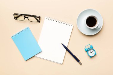 Defterli modern ofis masası ve bir fincan kahveli diğer malzemeler. Tasarım için boş defter sayfası. Üst manzara, düz uzanma.