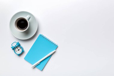 Defterli modern ofis masası ve bir fincan kahveli diğer malzemeler. Tasarım için boş defter sayfası. Üst manzara, düz uzanma.