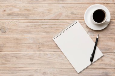 Defterli modern ofis masası ve bir fincan kahveli diğer malzemeler. Tasarım için boş defter sayfası. Üst manzara, düz uzanma.