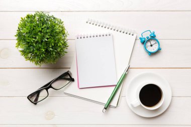 Defterli modern ofis masası ve bir fincan kahveli diğer malzemeler. Tasarım için boş defter sayfası. Üst manzara, düz uzanma.