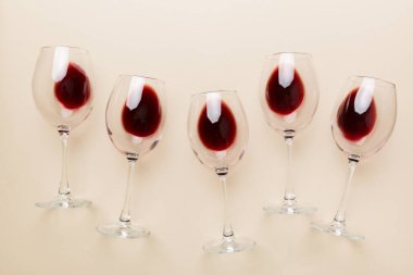 Şarap tadımında bir sürü kırmızı şarap. Renkli arka planda kırmızı şarap kavramı. Üst görünüm, düz dizayn.