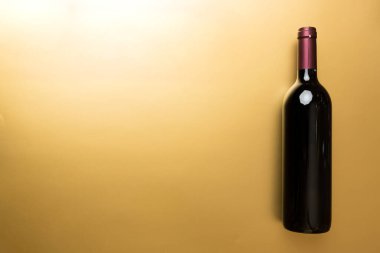 Renkli masada bir şişe kırmızı şarap. Düz konum, üst görünüm kopyalama alanı.