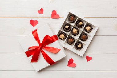 Sevgililer Günü için kırmızı kutuda lezzetli çikolatalı pralinler. Kalp şeklinde çikolata kutusu, fotokopi alanı ile üst görünüm..