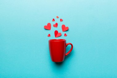 Renkli arka planda kırmızı bardak, kırmızı küçük kalpler, kopya alanı ile üst görünüm.
