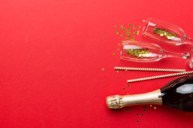 Şampanya şişesi, simler ve renkli pipetler. Üst Manzara. Komik, noel ve doğum günü kutlaması.