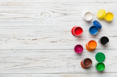 Renkli arka planda farklı renkte gagalı kavanozlar. Hobi resim. Boşluğu olan üst görünüm. Yaratıcılık için işyeri. ev öğretmenliği kavramı çizimi.