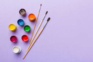 Boya ve fırçalı palet, yakın çekim. Boşluğu olan üst görünüm. Yaratıcılık için işyeri. ev öğretmenliği kavramı çizimi.