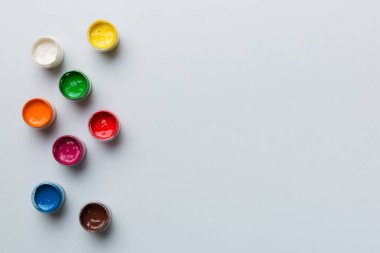 Renkli arka planda farklı renkte gagalı kavanozlar. Hobi resim. Boşluğu olan üst görünüm. Yaratıcılık için işyeri. ev öğretmenliği kavramı çizimi.