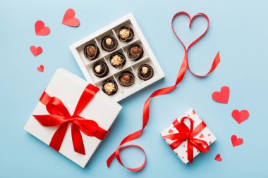 Sevgililer Günü için kutuda lezzetli çikolatalı pralinler. Kalp, hediye kutusuyla şekillendirilmiş çikolatalar fotokopi alanı ile üst görünüm.