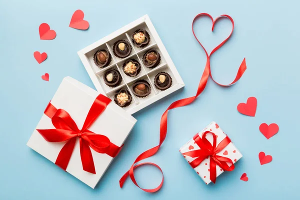 Sevgililer Günü için kutuda lezzetli çikolatalı pralinler. Kalp, hediye kutusuyla şekillendirilmiş çikolatalar fotokopi alanı ile üst görünüm.