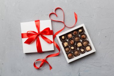 Sevgililer Günü için kırmızı kutuda lezzetli çikolatalı pralinler. Kalp şeklinde çikolata kutusu, fotokopi alanı ile üst görünüm..