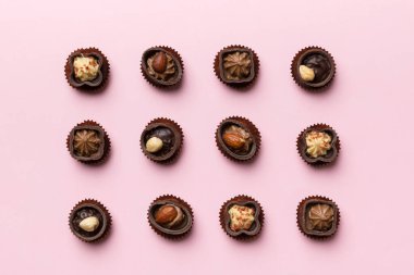 Renkli masa üzerinde farklı çikolata çeşitleri var. Üst Görünüm ve Düz Yatay.