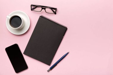 Modern ofis masası, defter, akıllı telefon ve kahve ile birlikte diğer malzemeler. Tasarım için boş defter sayfası. Üst manzara, düz uzanma.