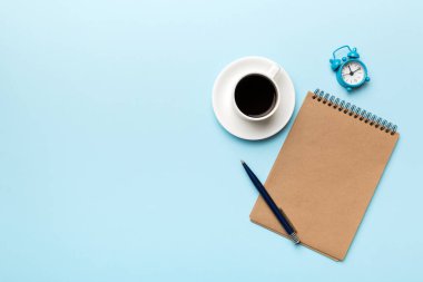 Defterli modern ofis masası ve bir fincan kahveli diğer malzemeler. Tasarım için boş defter sayfası. Üst manzara, düz uzanma.