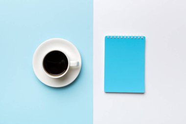 Defterli modern ofis masası ve bir fincan kahveli diğer malzemeler. Tasarım için boş defter sayfası. Üst manzara, düz uzanma.