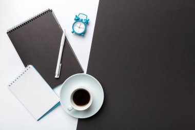 Defterli modern ofis masası ve bir fincan kahveli diğer malzemeler. Tasarım için boş defter sayfası. Üst manzara, düz uzanma.