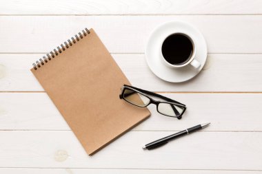 Defterli modern ofis masası ve bir fincan kahveli diğer malzemeler. Tasarım için boş defter sayfası. Üst manzara, düz uzanma.