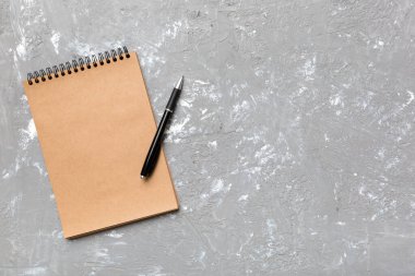 Renkli bir arka planda okul kahverengi defteri, bir masadaki spiral el işi not defteri..