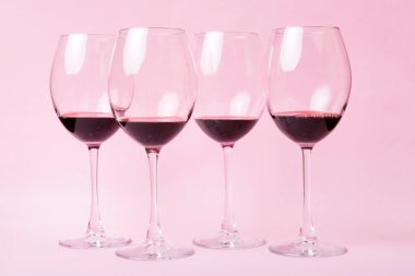 Şarap tadımında bir sürü kırmızı şarap. Renkli arka planda kırmızı şarap kavramı. Üst görünüm, düz dizayn.