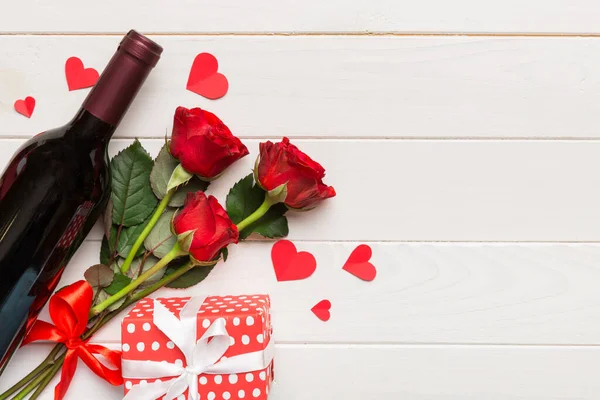 Kırmızı şarap, gül çiçeği ve hediye kutusuyla Sevgililer Günü kompozisyonu. Üst manzara, düz yatış. Tatil kavramı.