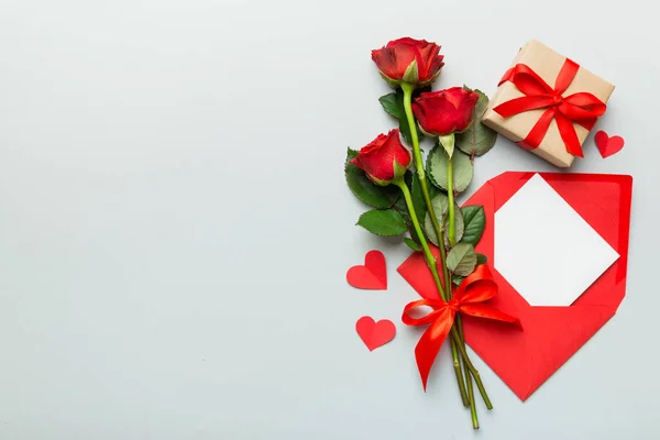 Valentine day composition with Envelope, rose flower and Red heart on table. Top view, flat lay. Holiday concept.