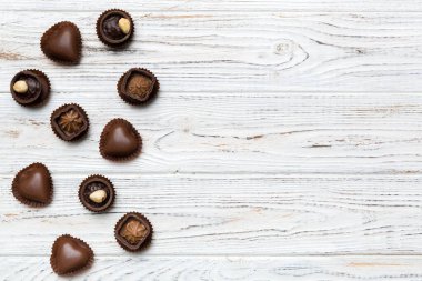 Renkli masa üzerinde farklı çikolata çeşitleri var. Kopya alanı ile Üst Görünüm ve Düz Yatay.