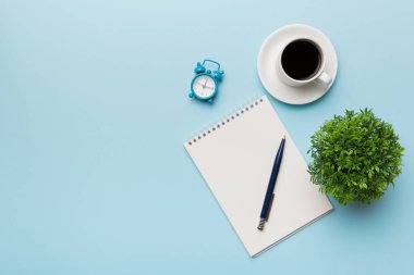 Defterli modern ofis masası ve bir fincan kahveli diğer malzemeler. Tasarım için boş defter sayfası. Üst manzara, düz uzanma.