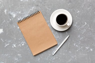 Defterli modern ofis masası ve bir fincan kahveli diğer malzemeler. Tasarım için boş defter sayfası. Üst manzara, düz uzanma.