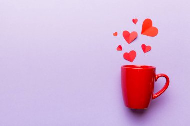 Renkli arka planda kırmızı bardak, kırmızı küçük kalpler, kopya alanı ile üst görünüm.