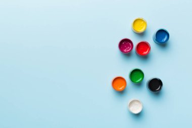 Renkli arka planda farklı renkte gagalı kavanozlar. Hobi resim. Boşluğu olan üst görünüm. Yaratıcılık için işyeri. ev öğretmenliği kavramı çizimi.