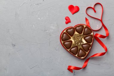 Sevgililer Günü için kırmızı kutuda lezzetli çikolatalı pralinler. Kalp şeklinde çikolata kutusu, fotokopi alanı ile üst görünüm..