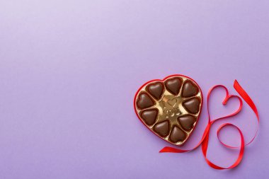 Sevgililer Günü için kırmızı kutuda lezzetli çikolatalı pralinler. Kalp şeklinde çikolata kutusu, fotokopi alanı ile üst görünüm..