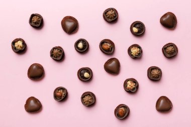 Renkli masa üzerinde farklı çikolata çeşitleri var. Üst Görünüm ve Düz Yatay.