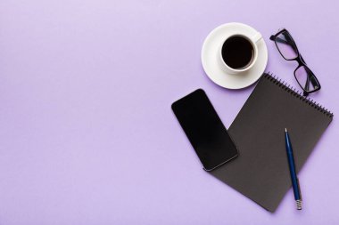 Modern ofis masası, defter, akıllı telefon ve kahve ile birlikte diğer malzemeler. Tasarım için boş defter sayfası. Üst manzara, düz uzanma.
