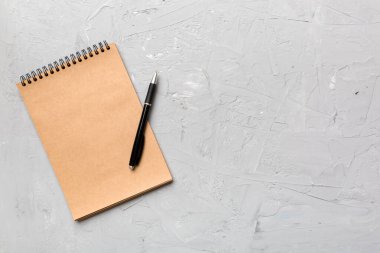 Renkli bir arka planda okul kahverengi defteri, bir masadaki spiral el işi not defteri..