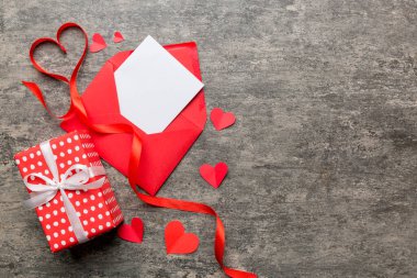 Renkli arka planda beyaz kart ve kalp olan kırmızı kağıt zarf. Top view Sevgililer Günü konsepti.