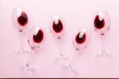 Mnoho sklenic červeného vína na ochutnávce vína. Koncept červeného vína na barevném pozadí. Pohled shora, plochý design.