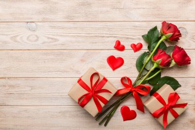Gül çiçeği, kırmızı kalp ve hediye kutularıyla Sevgililer Günü kompozisyonu. Anneler günü ve doğum günü tebriği, kopyalama alanı, üst görünüm.