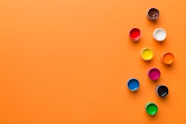 Renkli arka planda farklı renkte gagalı kavanozlar. Hobi resim. Boşluğu olan üst görünüm. Yaratıcılık için işyeri. ev öğretmenliği kavramı çizimi.