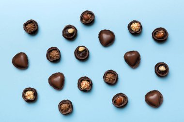 Renkli masa üzerinde farklı çikolata çeşitleri var. Üst Görünüm ve Düz Yatay.