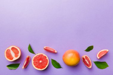 Renkli arka planda sulu greyfurt dilimli taze meyve greyfurdu. Üst Manzara. Uzayı kopyala yaratıcı yaz konsepti. Minimum düzlükte turunçgillerin yarısı kopyalama alanı ile yatar.