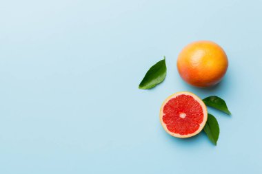 Renkli arka planda sulu greyfurt dilimli taze meyve greyfurdu. Üst Manzara. Uzayı kopyala yaratıcı yaz konsepti. Minimum düzlükte turunçgillerin yarısı kopyalama alanı ile yatar.