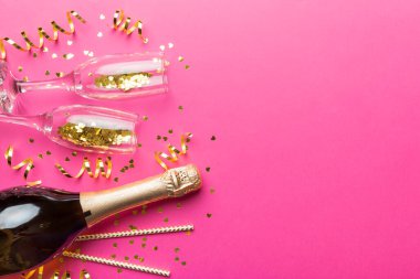 Şampanya şişesi, simler ve renkli pipetler. Üst Manzara. Komik, noel ve doğum günü kutlaması.