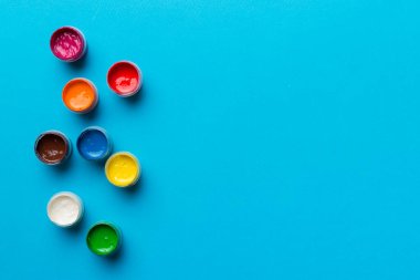 Renkli arka planda farklı renkte gagalı kavanozlar. Hobi resim. Boşluğu olan üst görünüm. Yaratıcılık için işyeri. ev öğretmenliği kavramı çizimi.