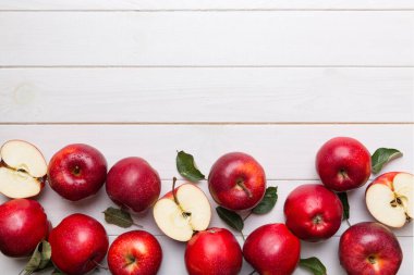 Tahta masada yeşil yapraklı taze kırmızı elmalar. Ahşap arka planda. Metin için üst görünüm boş alanı.