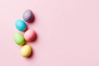 Bayram hazırlığı. Renkli arka planda Paskalya yumurtaları. Pastel renginde Paskalya yumurtası. Kopyalama alanı olan tatil kavramı.