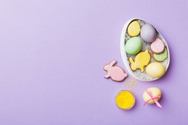 Renkli paskalya kurabiyeleri sepette renkli arka planda çok renkli Paskalya yumurtaları. Pastel renginde Paskalya yumurtası. Kopyalama alanı olan tatil kavramı.